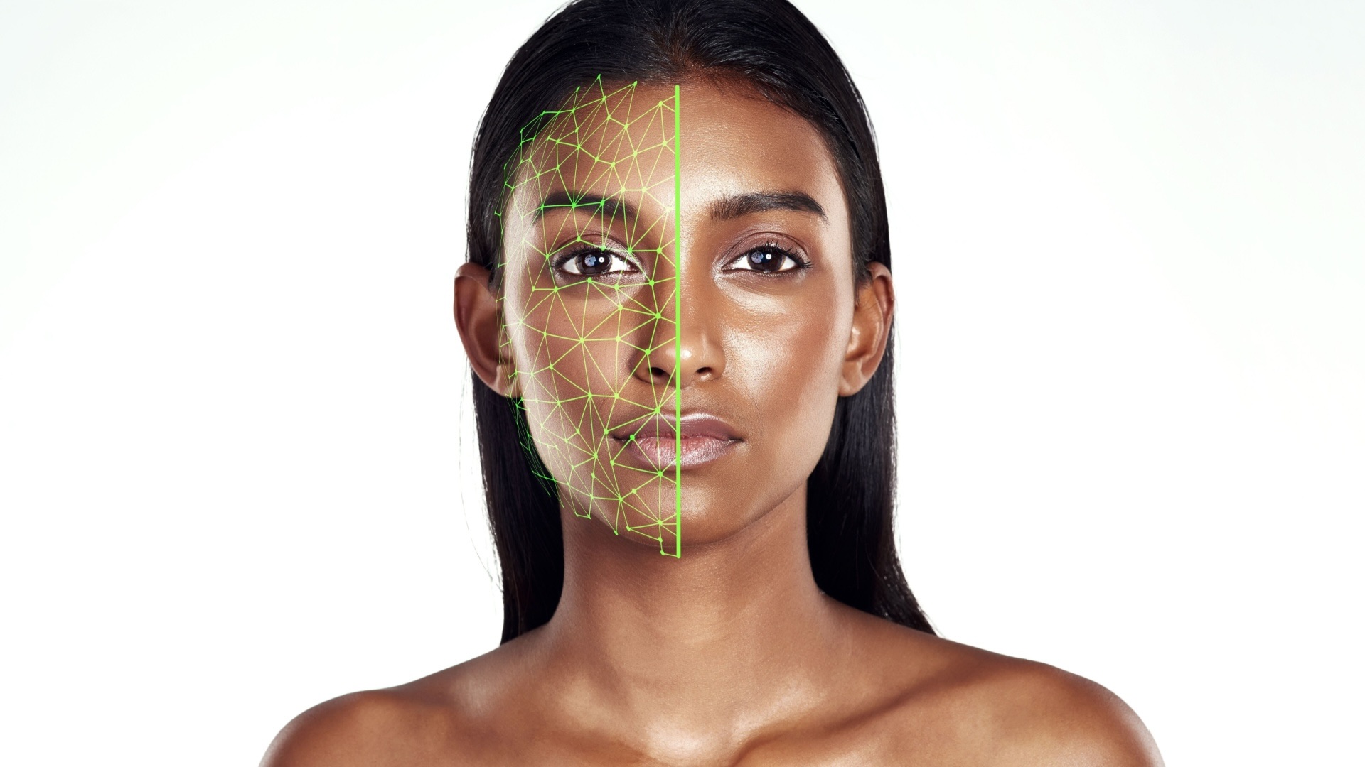 Studio portrait of a woman using facial recognition technology for skincare. The model is isolated against a white background, with a green hologram scanning the left side face to detect changes or enhancements.